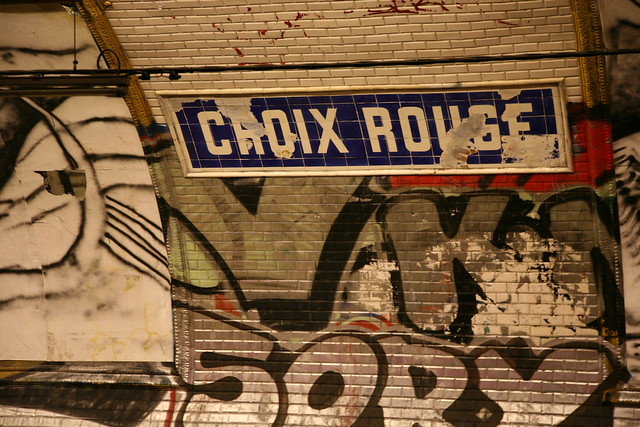 Dilapidated station name sign and graffiti in the Croix-Rouge metro station