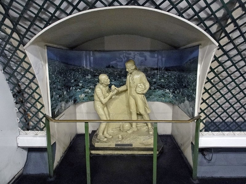 Statue of a man with a basket of potatoes, giving one to a an elderly pauper